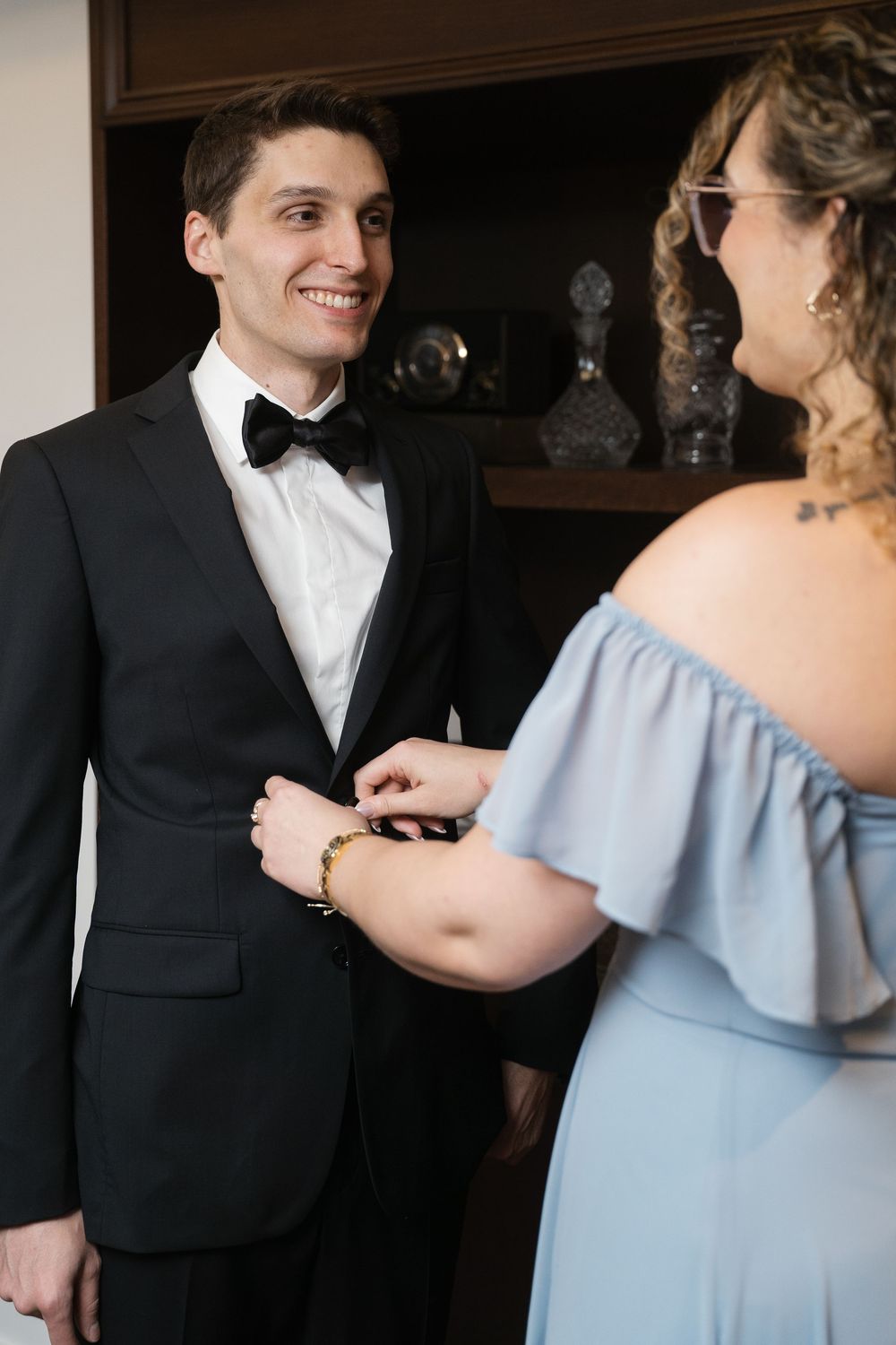A formal wedding moment showing final preparations in elegant attire.