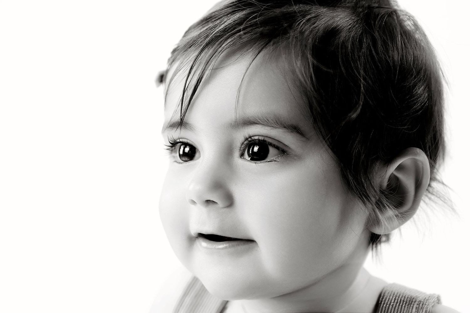 Close-up black and white portrait of a young child with big expressive eyes.