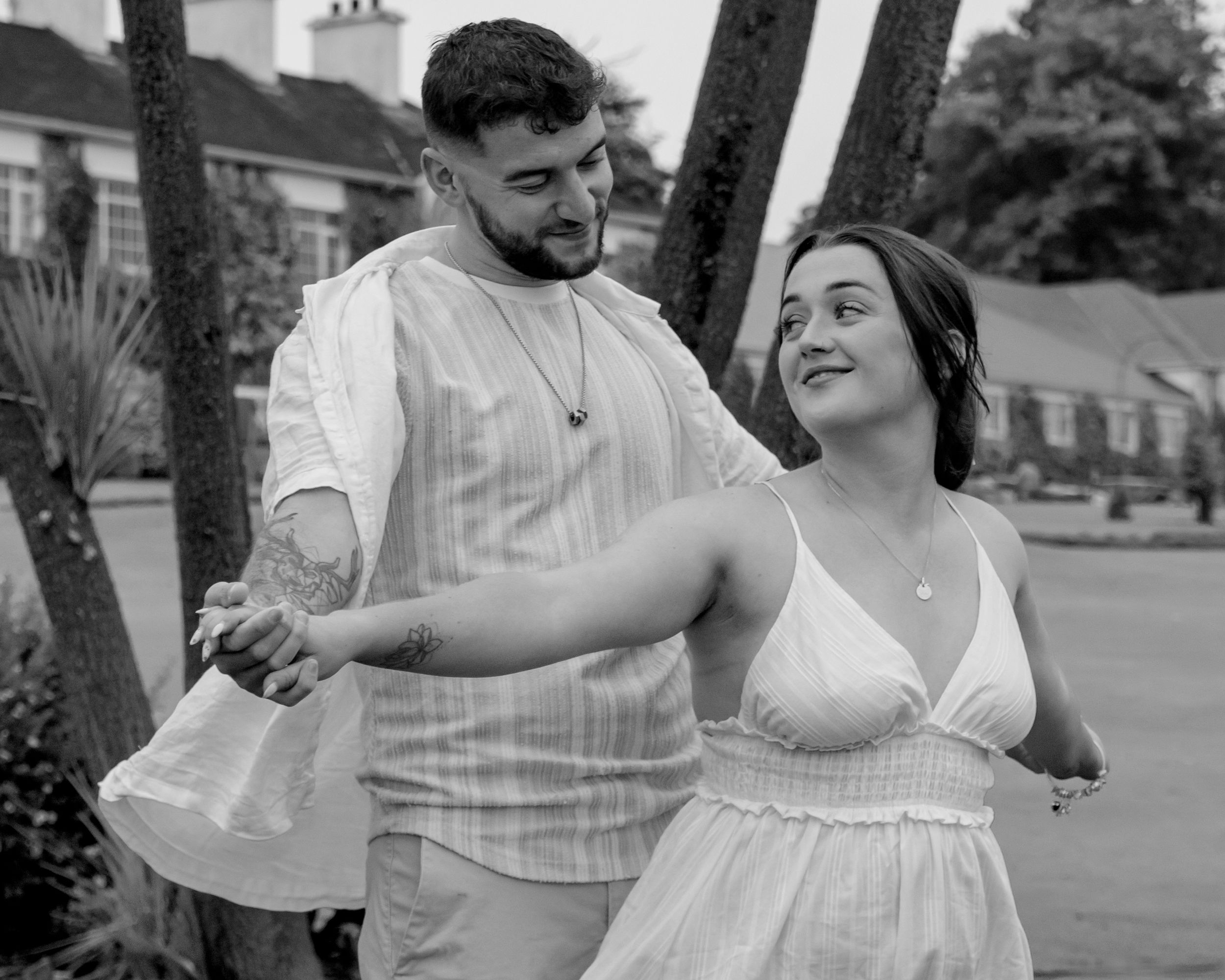 Black and white photo series of a couple dancing and embracing in a romantic outdoor setting.