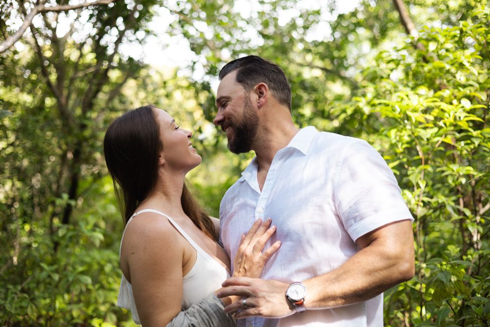 Couple staring into each others eyes with trees in background