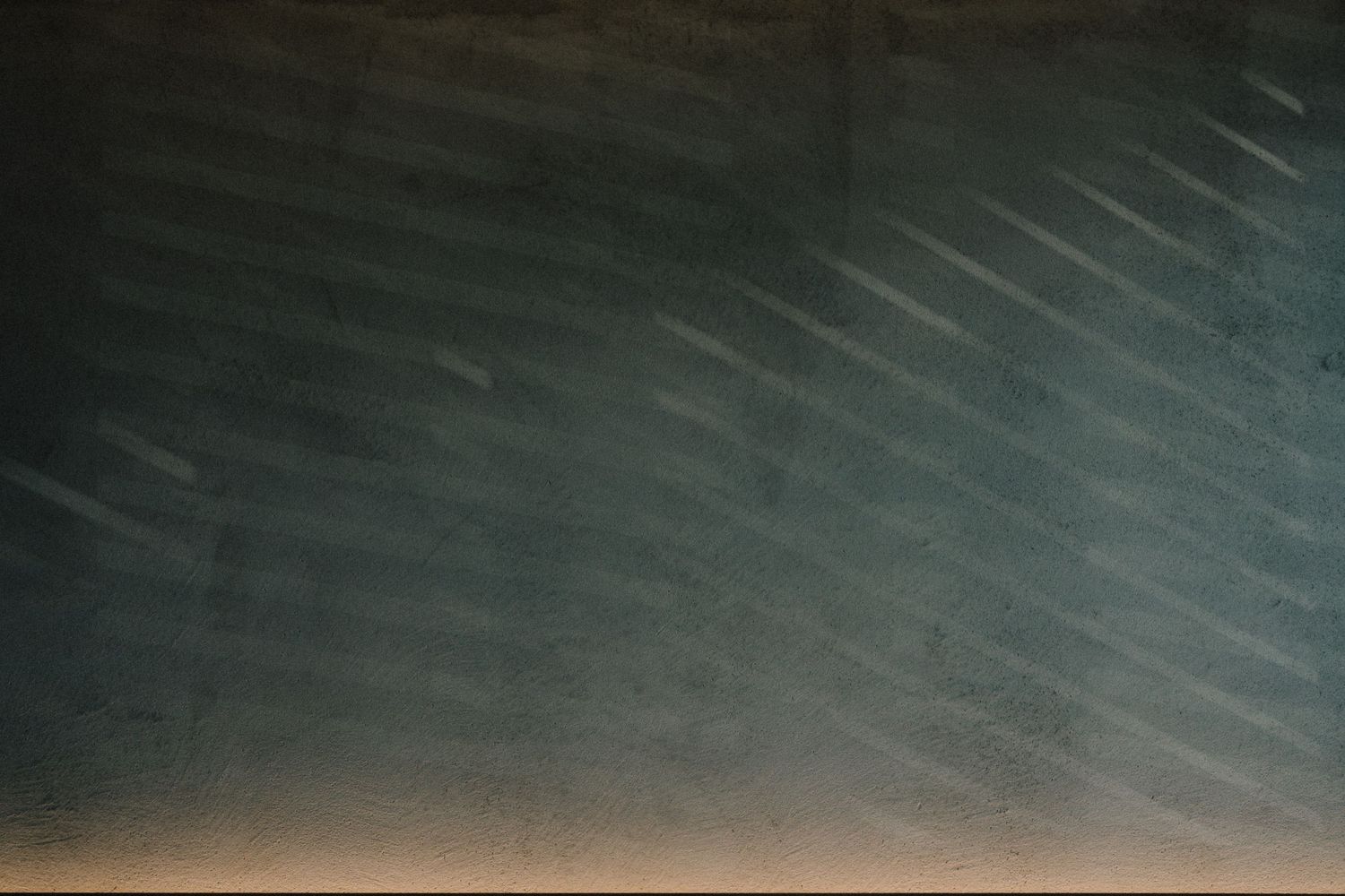 Abstract pattern of diagonal light streaks against dark background.