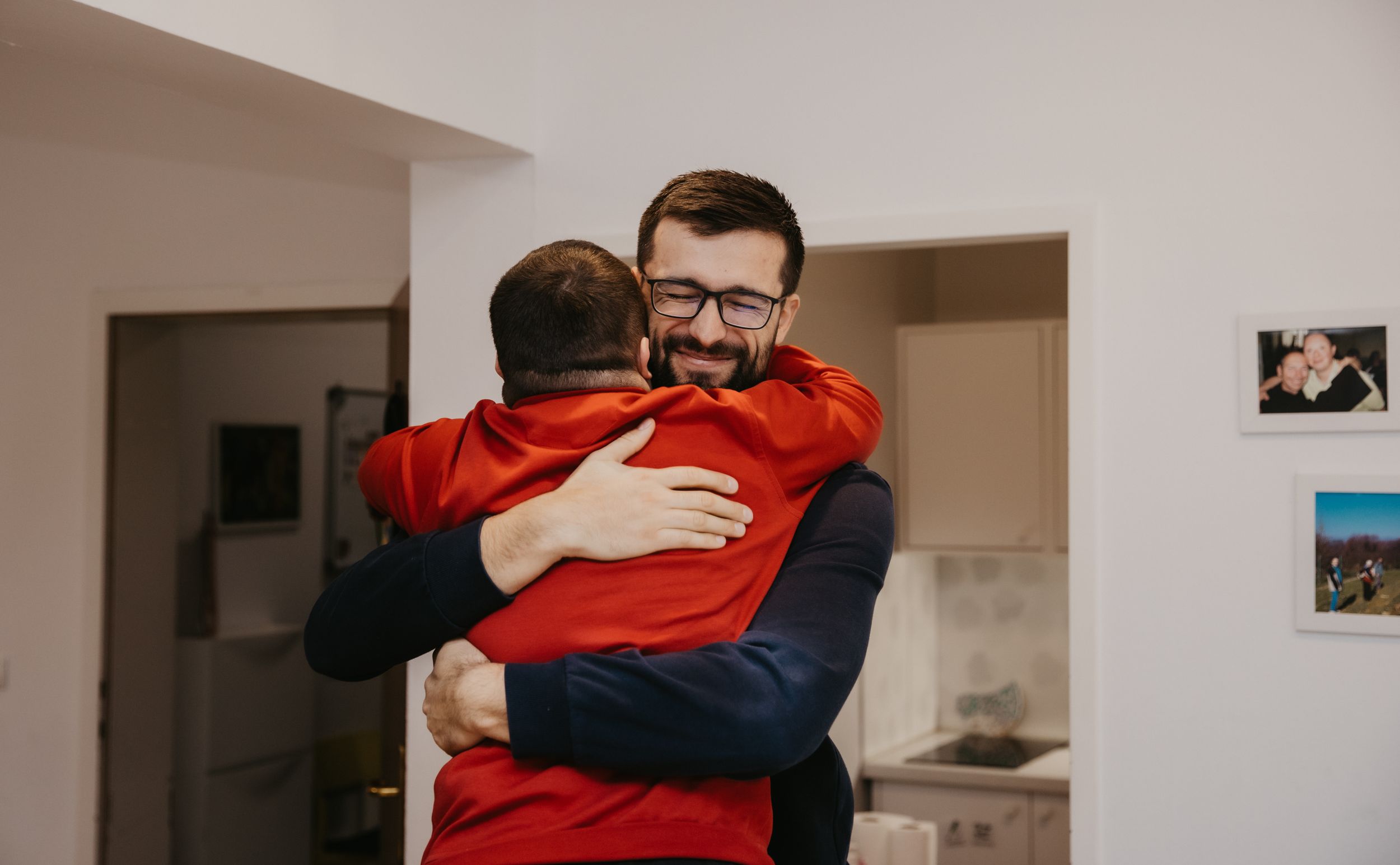 Close embrace shared in a home interior with white walls.