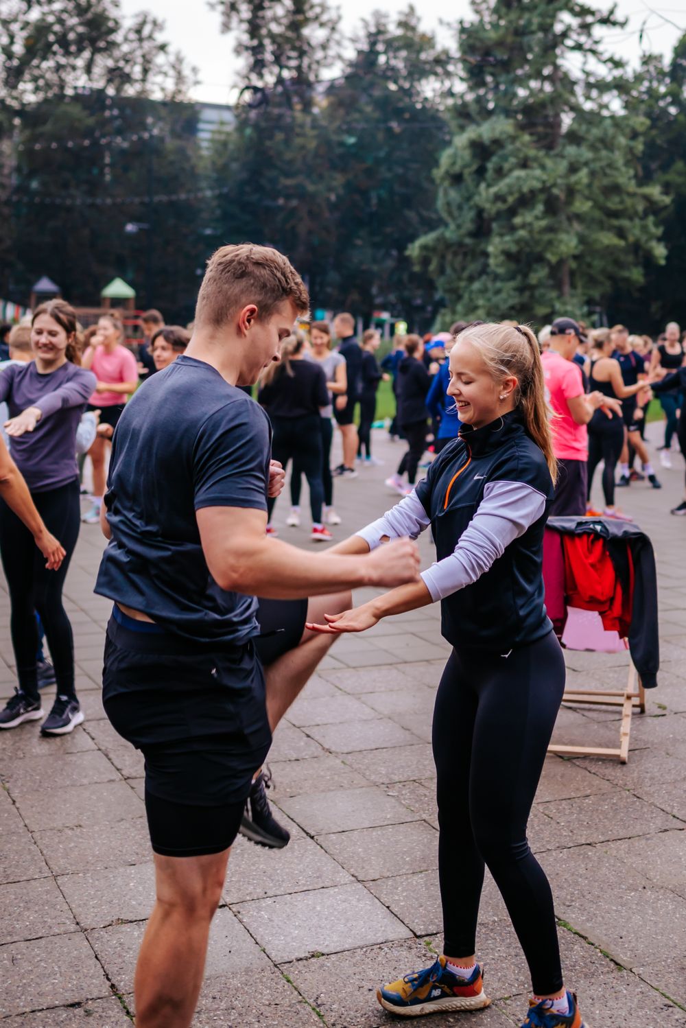 Participants interacting at an outdoor fitness event wearing athletic gear.
