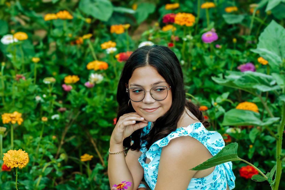 A playful portrait in a flower garden with vibrant marigolds and zinnias.