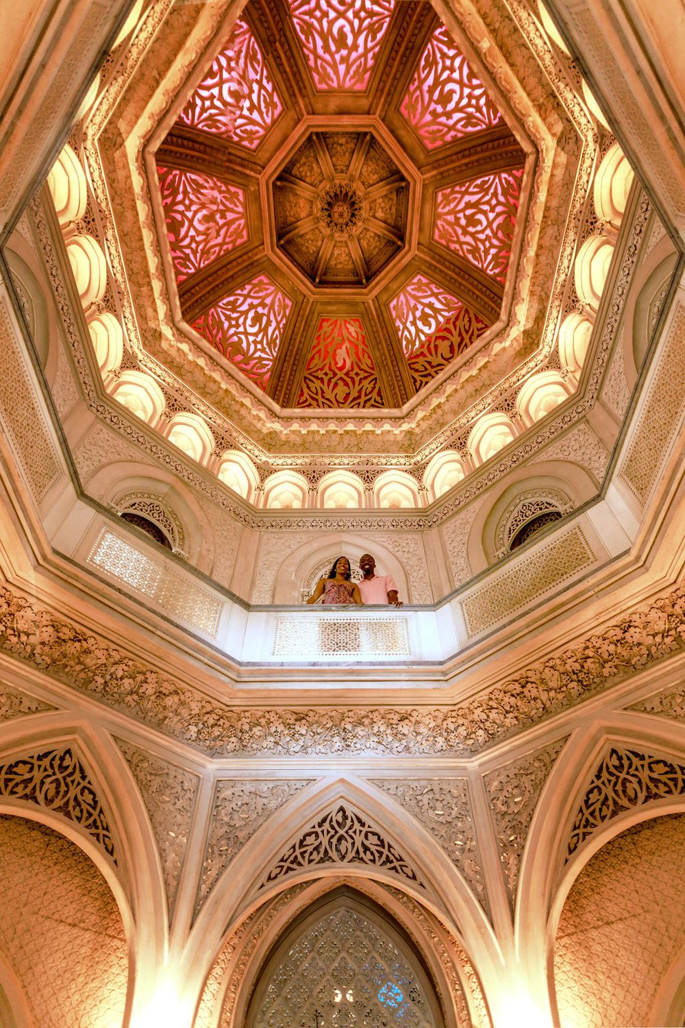 Ornate octagonal ceiling with intricate Islamic geometric patterns and red and gold decorative details in a historic mosque.