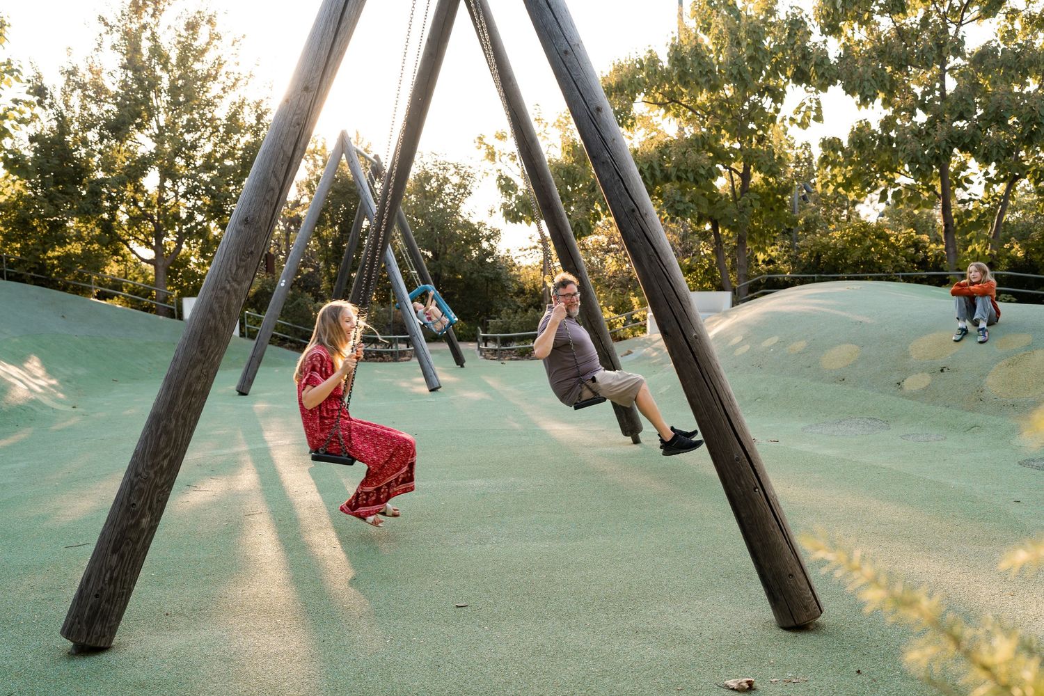 Tulsa family swings together at Gathering Place in Tulsa, Ok during a candid photography session.