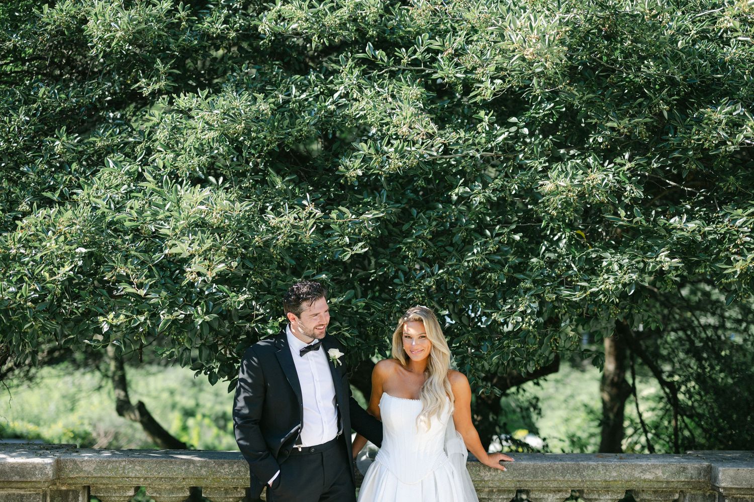 Elegant couple in wedding attire share romantic moments in a lush garden setting during their wedding photoshoot.