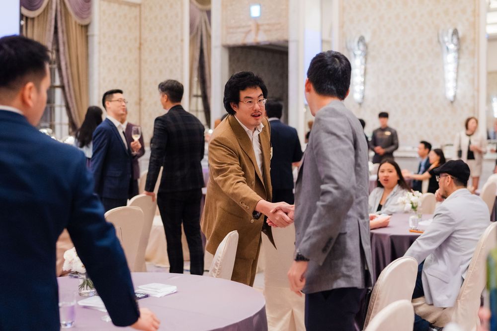 Business professionals networking and exchanging business cards at a formal corporate event in an elegant venue.