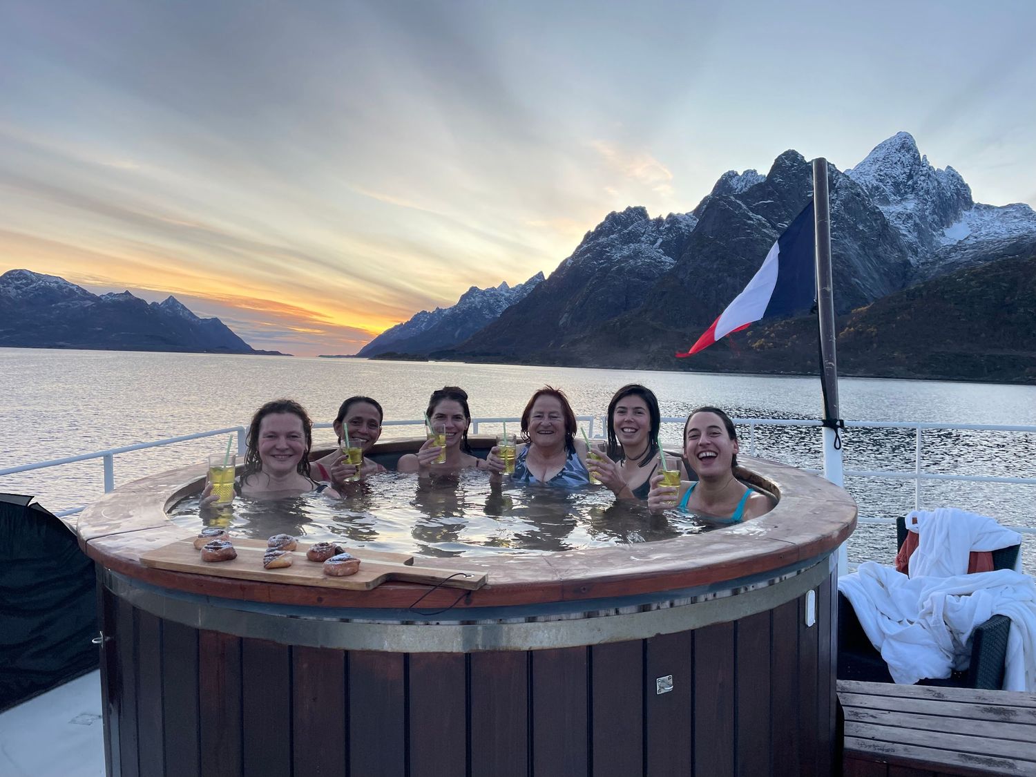 passagères de croisière latitude blanche dans le bain nordique au milieu du fjord au coucher du soleil