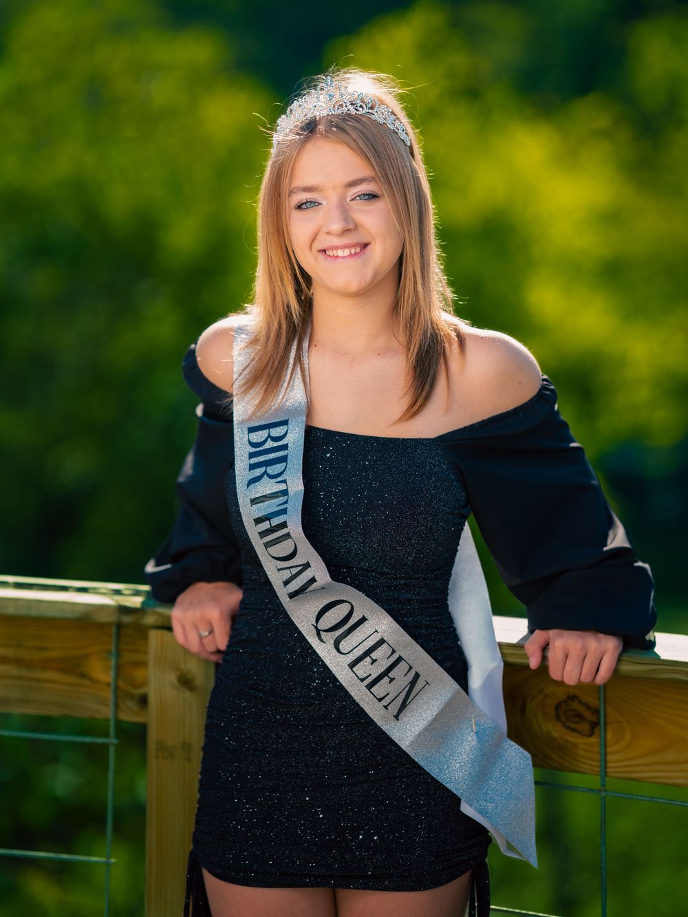 Teenager on sweet 16 birthday shoot with tiara and banner