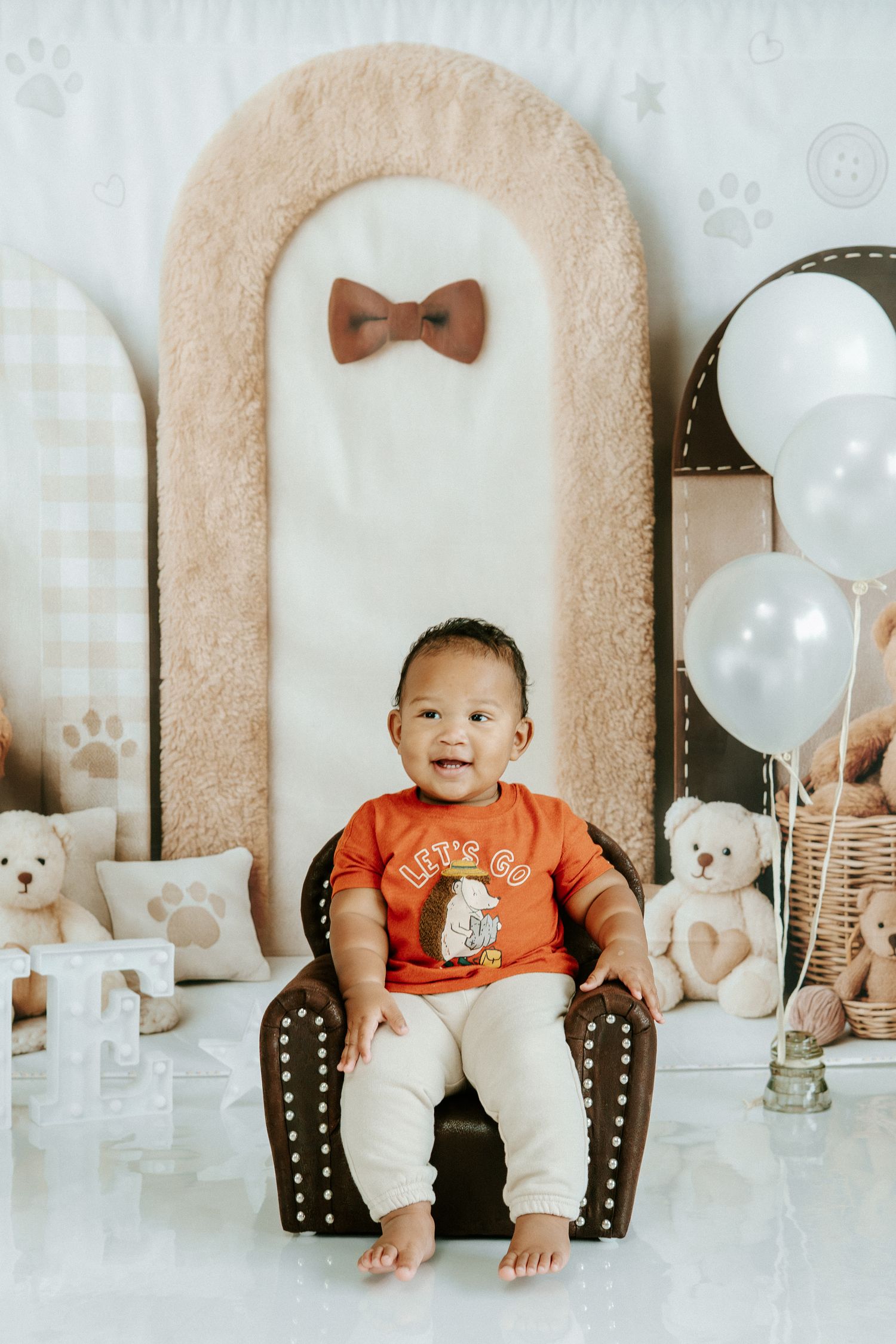 Baby milestone photos showing monthly growth progression in a white studio setting with teddy bears and balloons.
