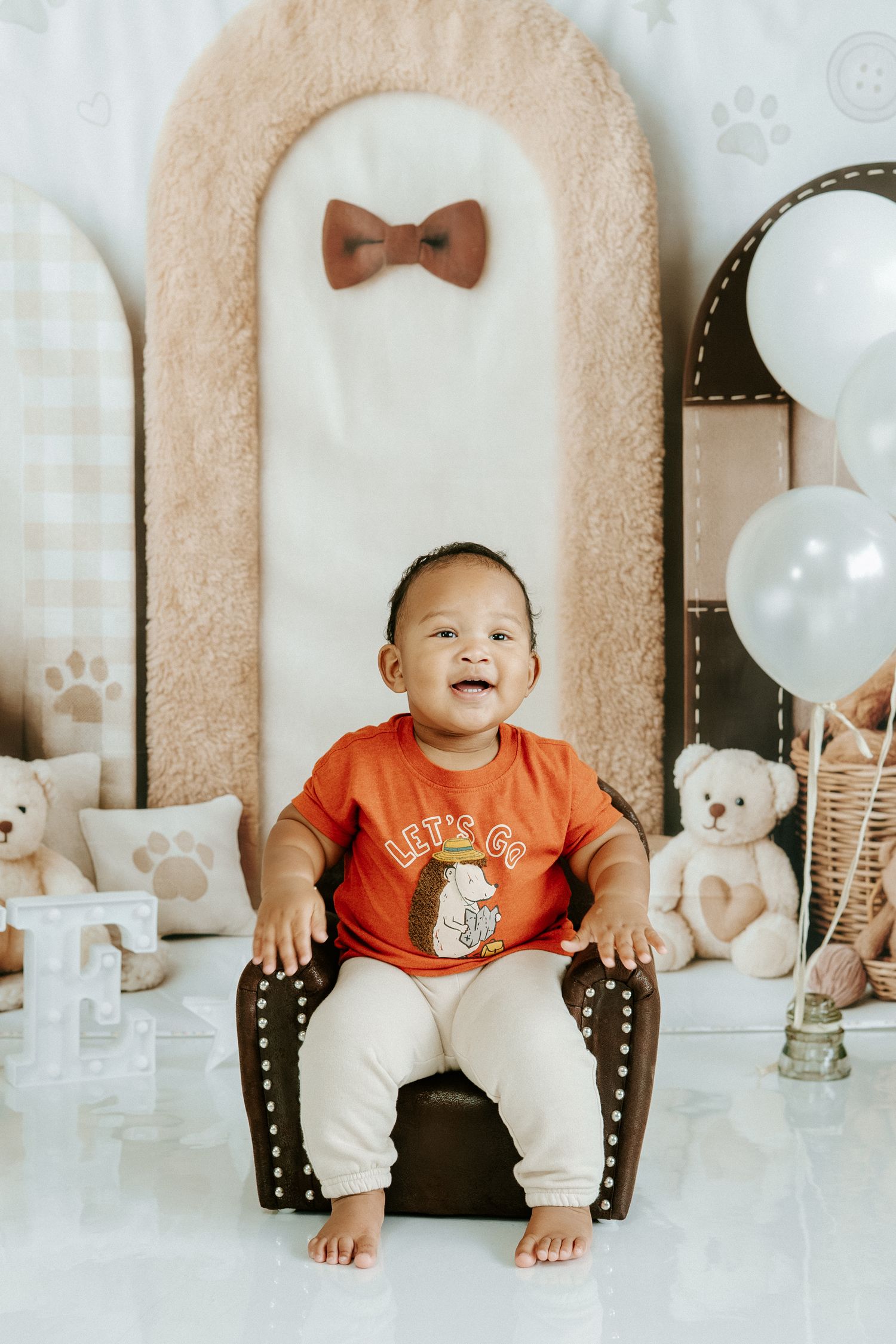 A series of five photos showing a baby in red outfit sitting in a chair with teddy bears and bow tie decorations.