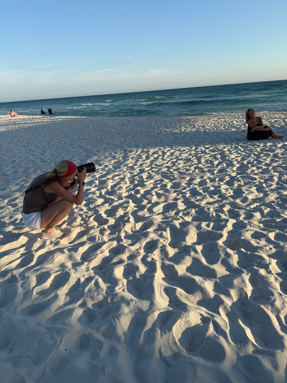 A series of photos showing people photographing on a pristine white sandy beach at sunset with turquoise ocean views.