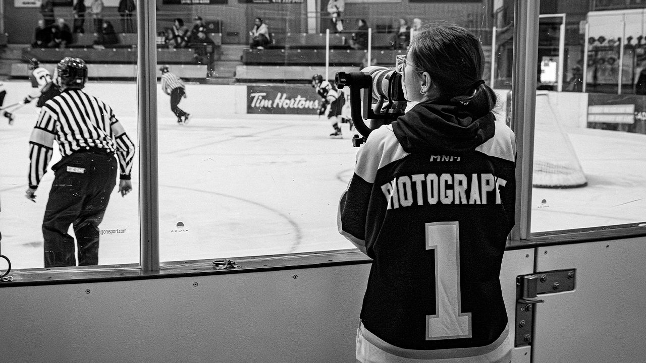 Panoramic view of a busy ice hockey game with players and officials on the rink during gameplay.