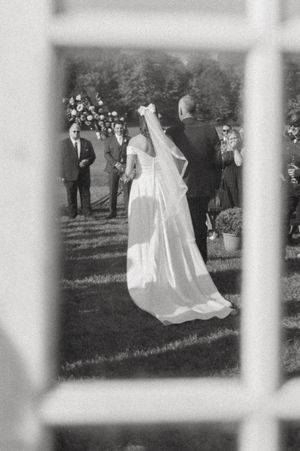 Black and white wedding ceremony photo captured through window panes.