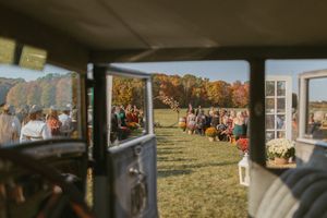 Panoramic view of outdoor wedding venue with guests gathered for ceremony.
