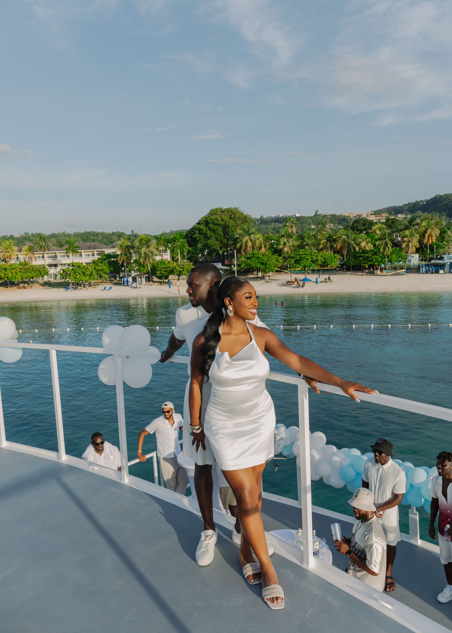 A sequence of photos showing someone in white attire leaning over a boat railing while enjoying a scenic ocean view.