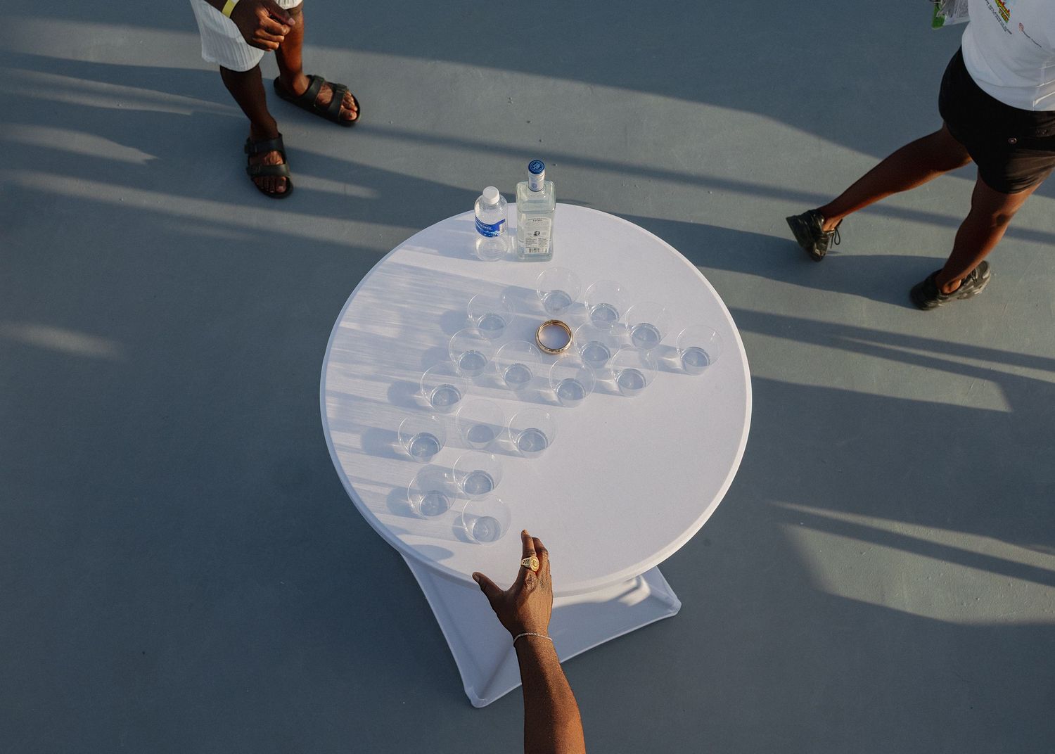 A person plays table tennis on a white circular ping pong table in an outdoor setting.