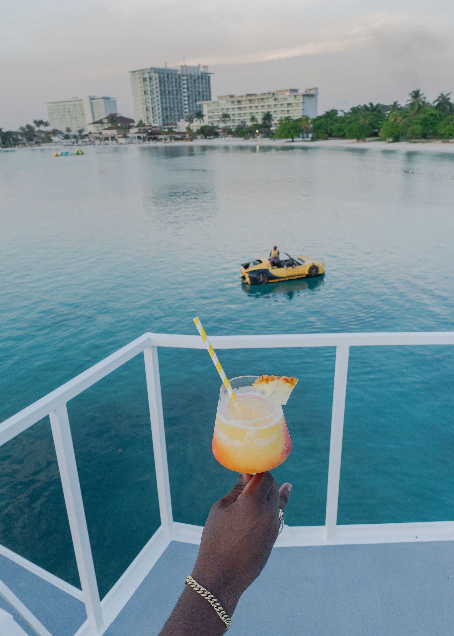 Scenic panoramic sequence of tropical waterfront views with cocktail drinks against turquoise ocean and city skyline.