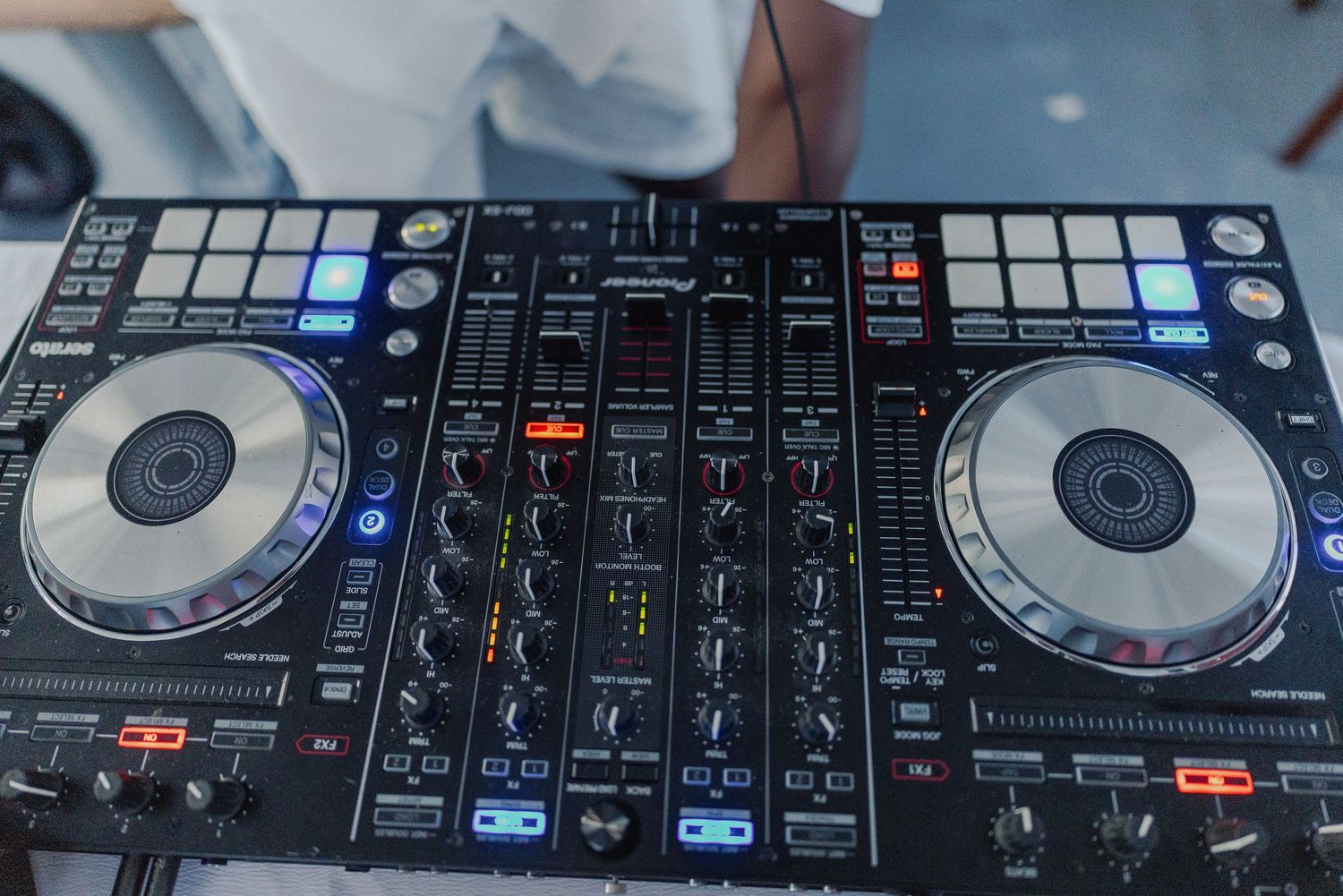 Professional DJ equipment setup with multiple turntables and mixing controllers in a dark environment.