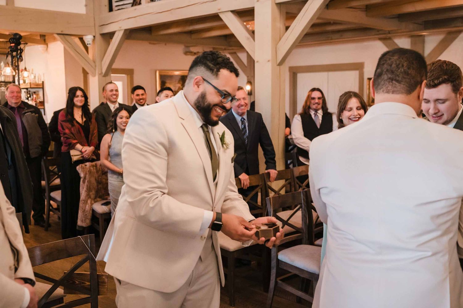 Groom smiling while receiving wedding rings during ceremony at Briar Barn Inn