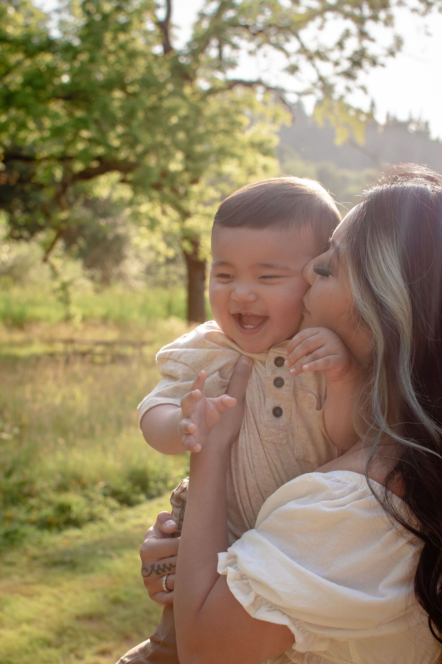Mother kissing her baby during outdoor motherhood photography session in Seattle Tacoma area