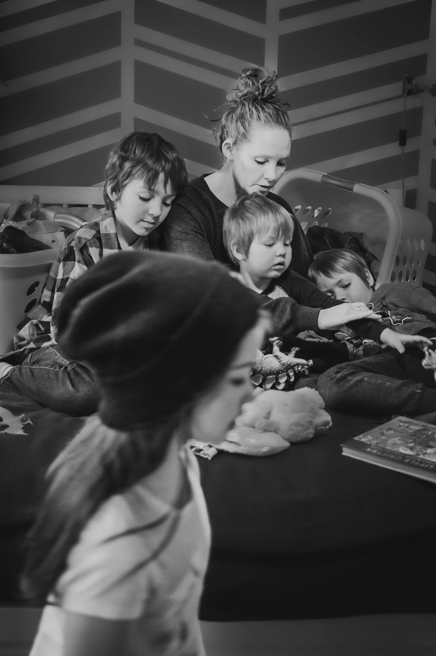 Brampton lifestyle photographer capturing a mother folding laundry and playing with her children at home