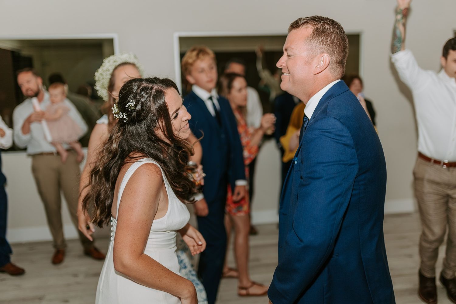 Bride and groom share a joyful first dance at their wedding reception at Tower Beach Club.