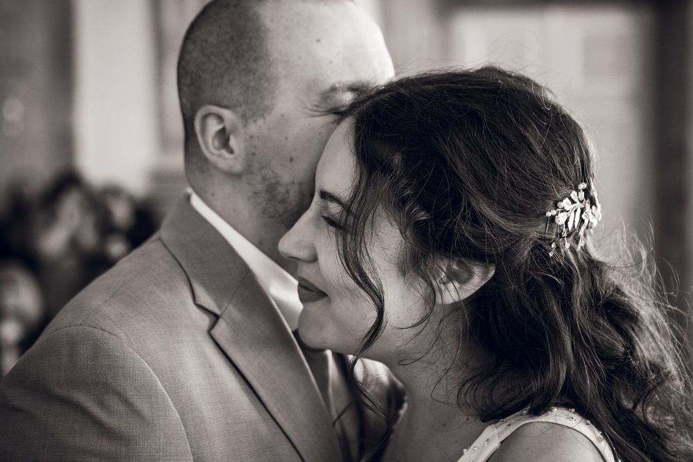 Romantic black and white close-up of bride and groom sharing an intimate moment at their wedding.
