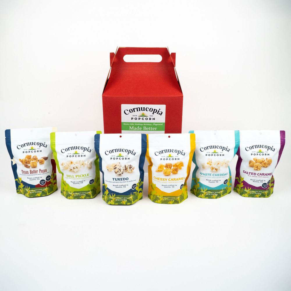 Red gift box with six bags of Carnivorous Plant Soil in various colors displayed in a row on white background.