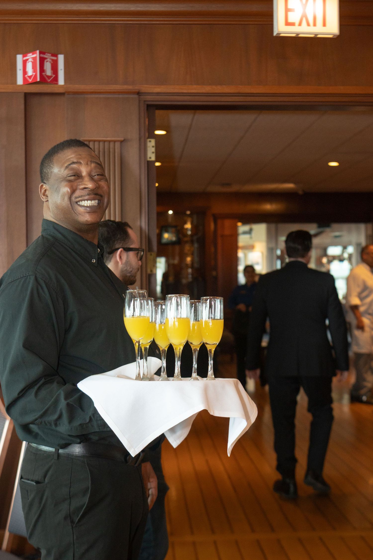 a waitor is holding a tray with drinks to serve people