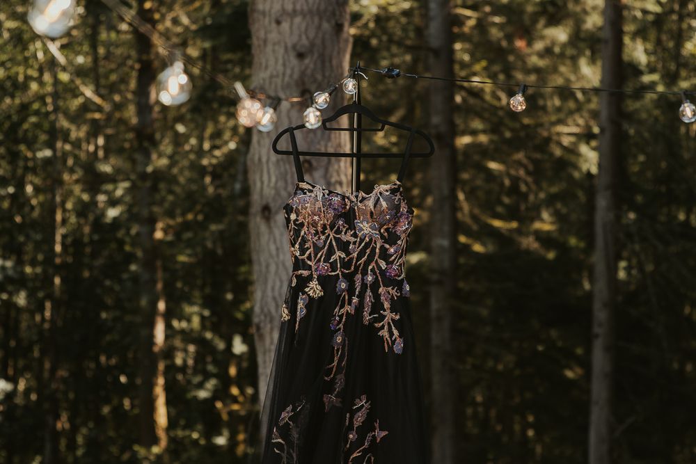 The bride’s elegant black lace wedding gown with intricate details during an outdoor ceremony
