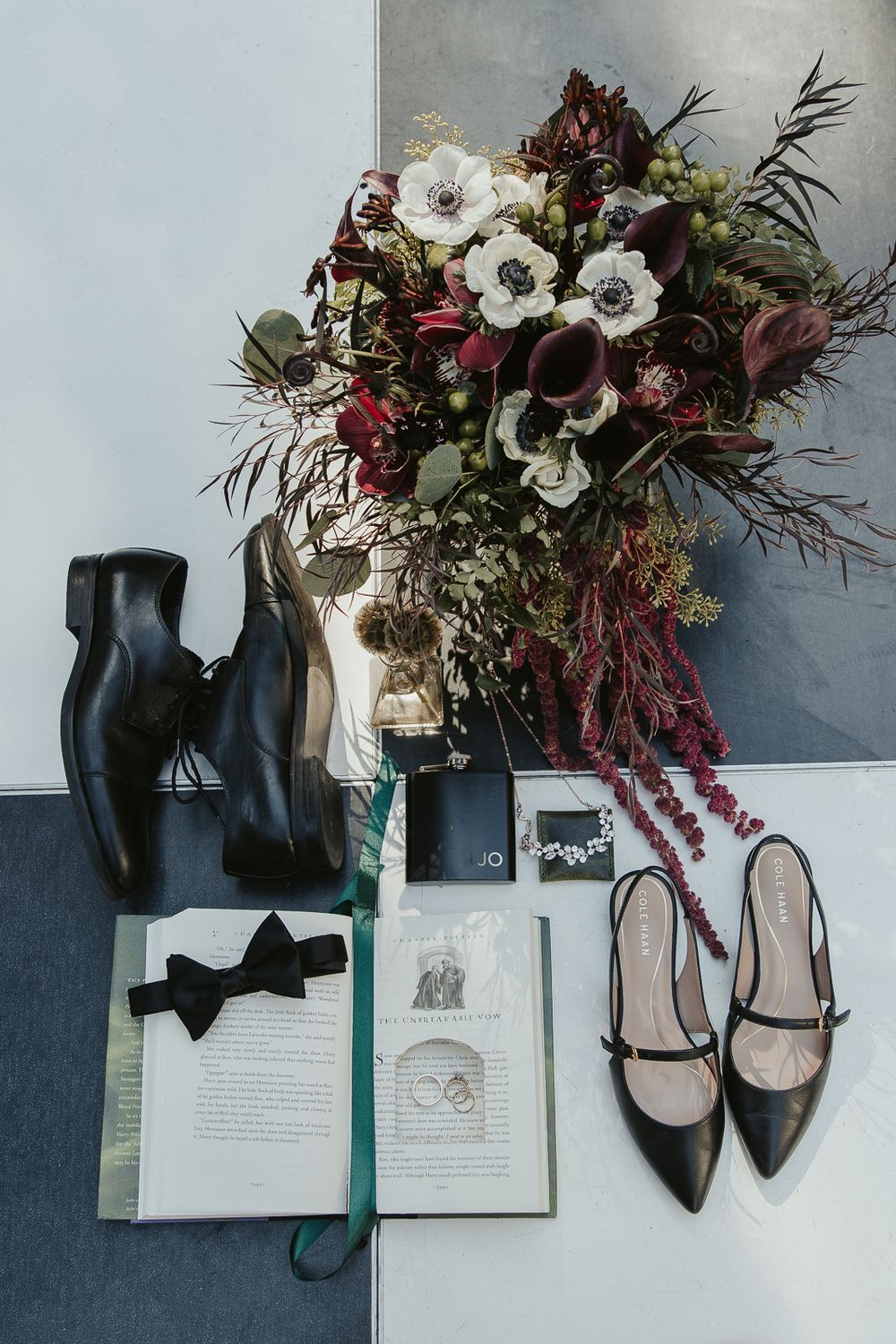 Flat lay of wedding stationery and details with a mix of spooky and elegant elements and dark florals