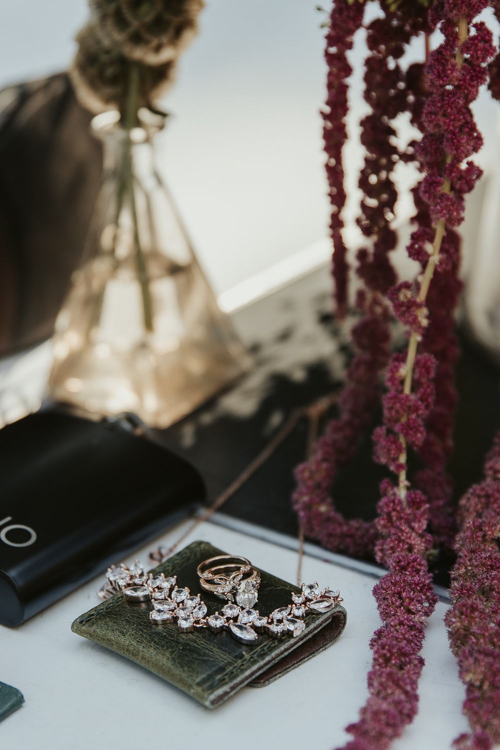 Flat lay of wedding stationery and details with a mix of spooky and elegant elements and dark florals