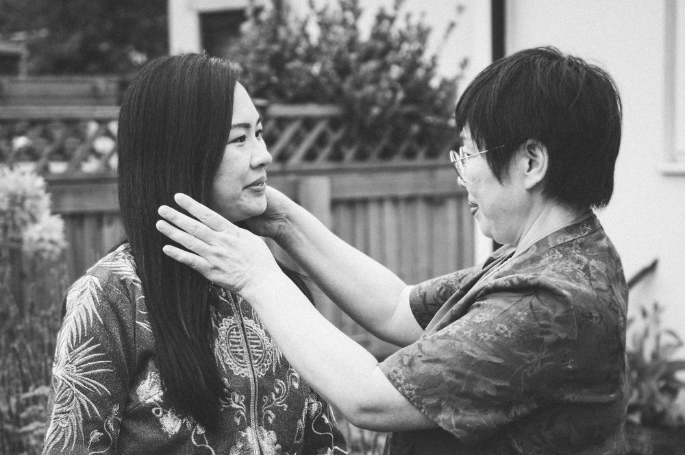 Black and white intimate moment between two people in traditional Asian formal wear.