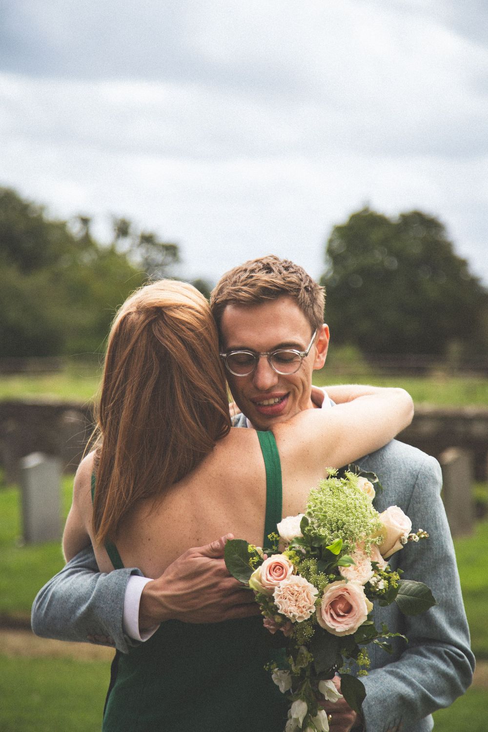Wedding guests share emotional hugs and congratulations during outdoor reception.