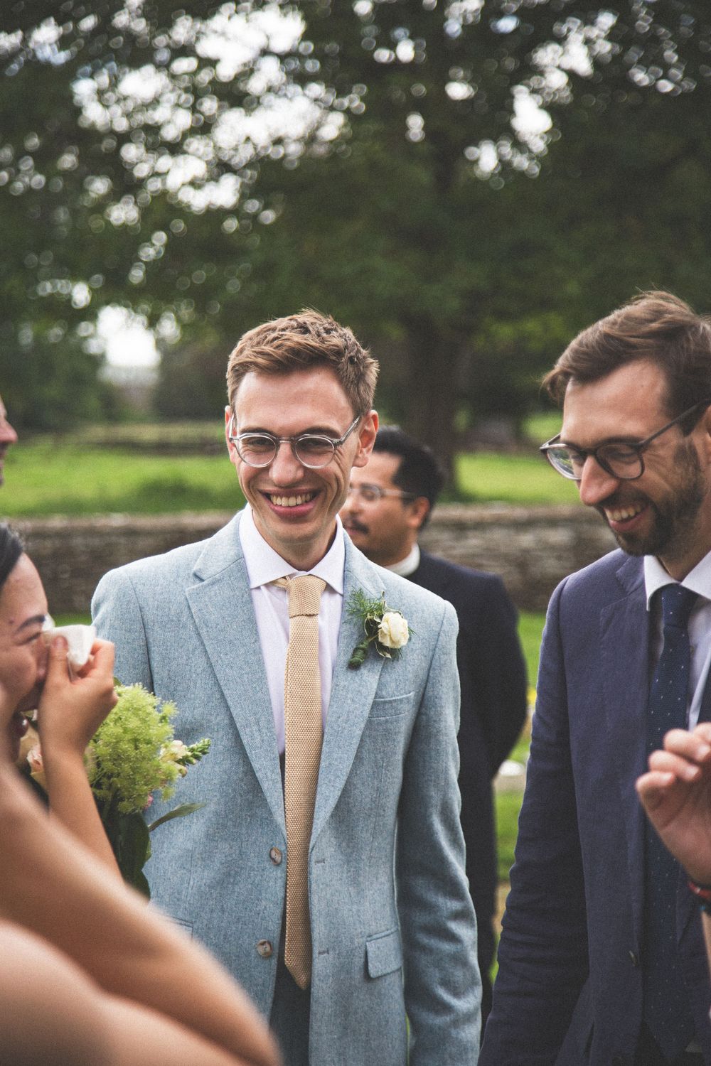 Candid laughter shared between guests during outdoor wedding reception.