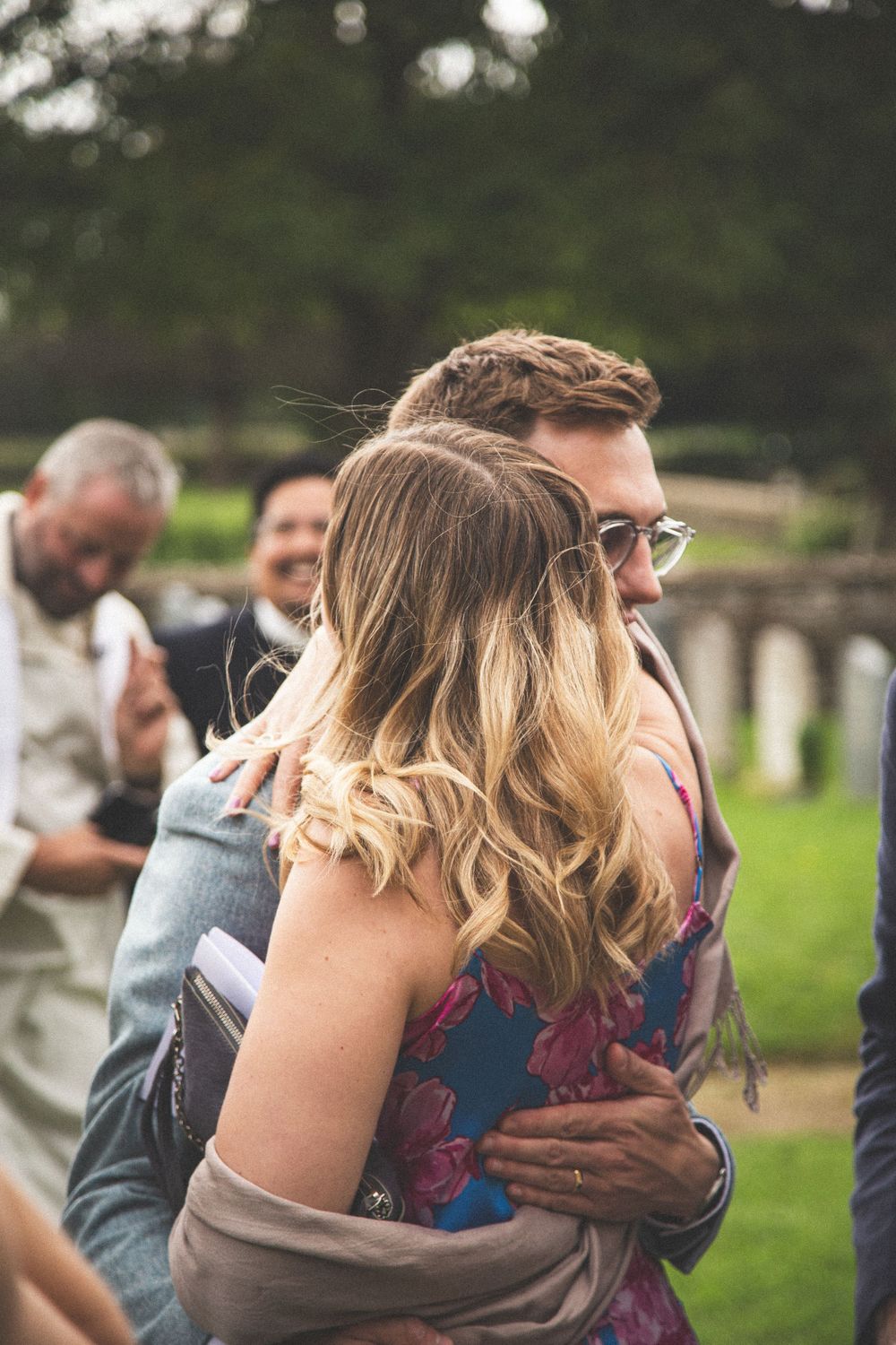 A couple shares an intimate embrace during an outdoor wedding celebration.