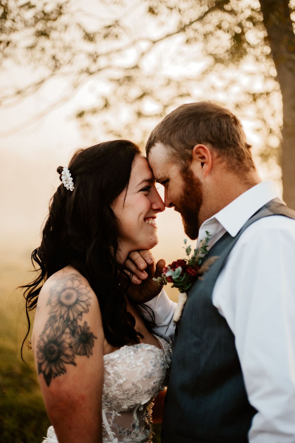 Romantic golden hour portrait of newlyweds sharing intimate moment outdoors.