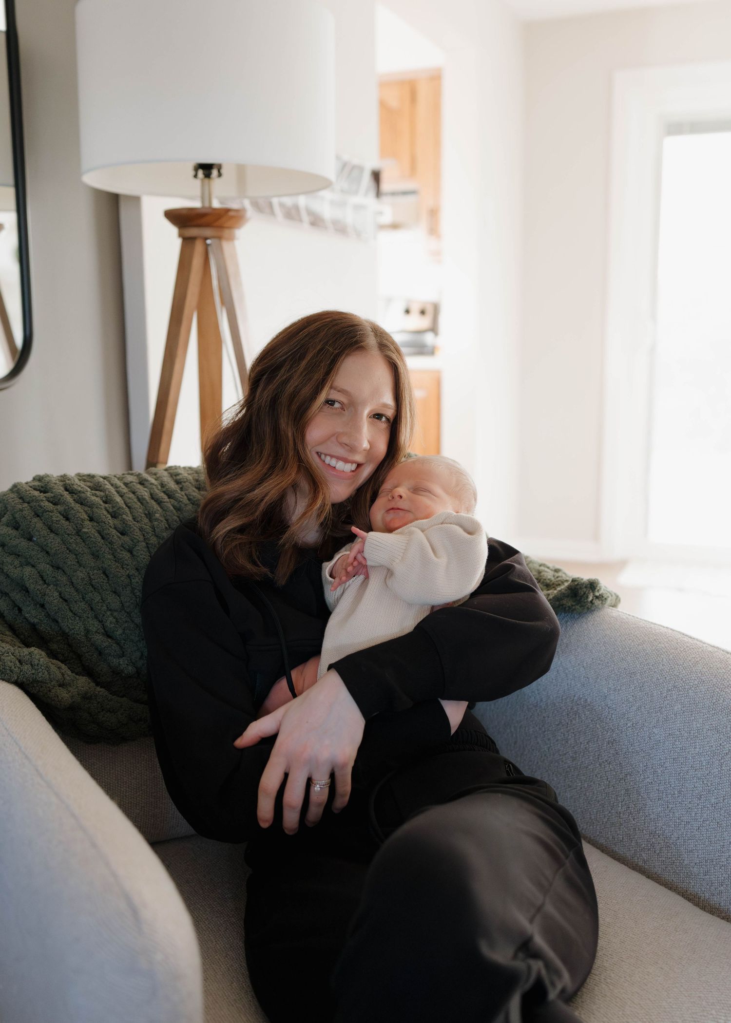 A tender moment of bonding in a bright living room with a cozy green sofa.