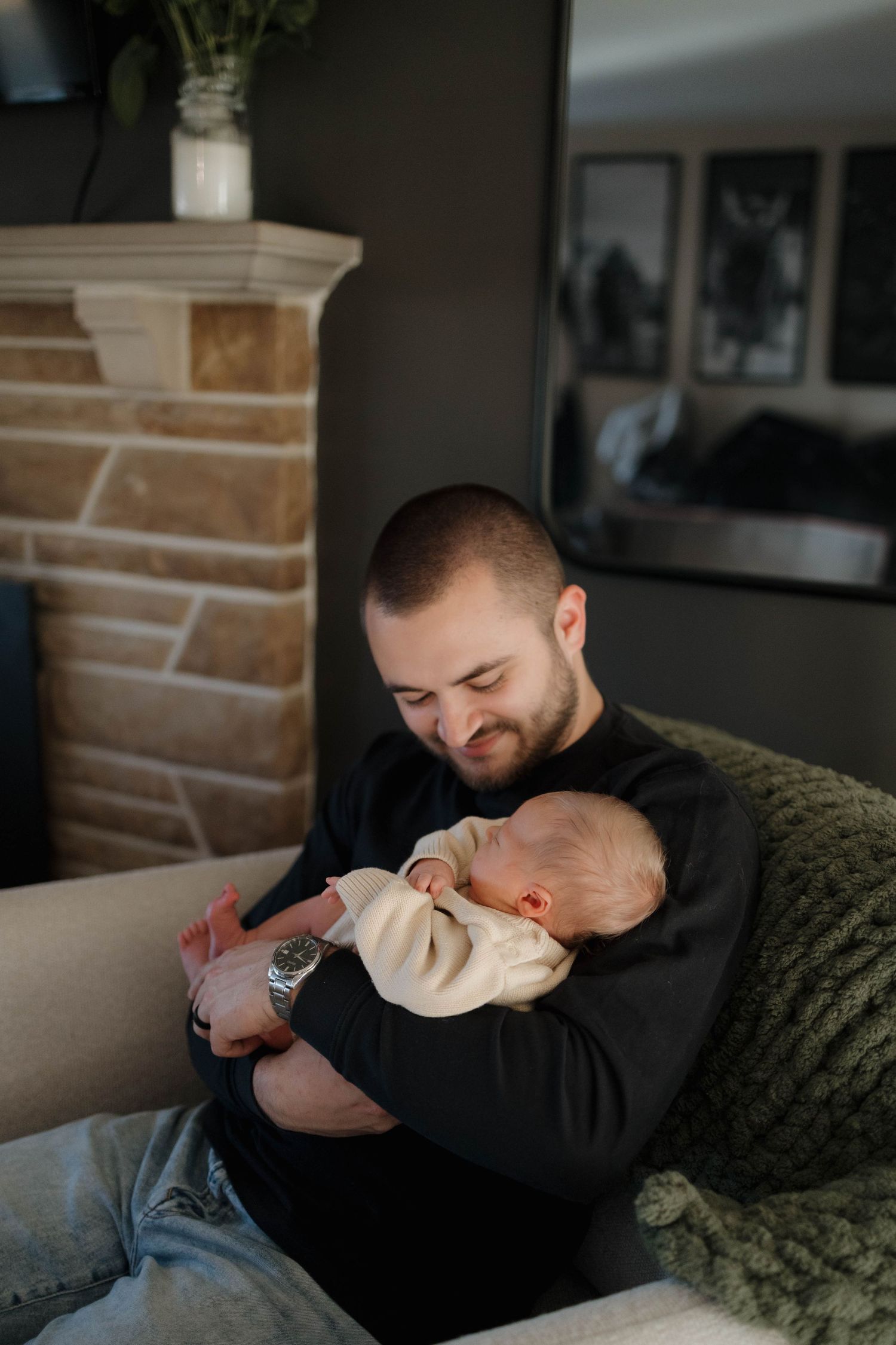 A tender moment of relaxation on the couch as a small baby is cradled in loving arms during a peaceful moment at home.
