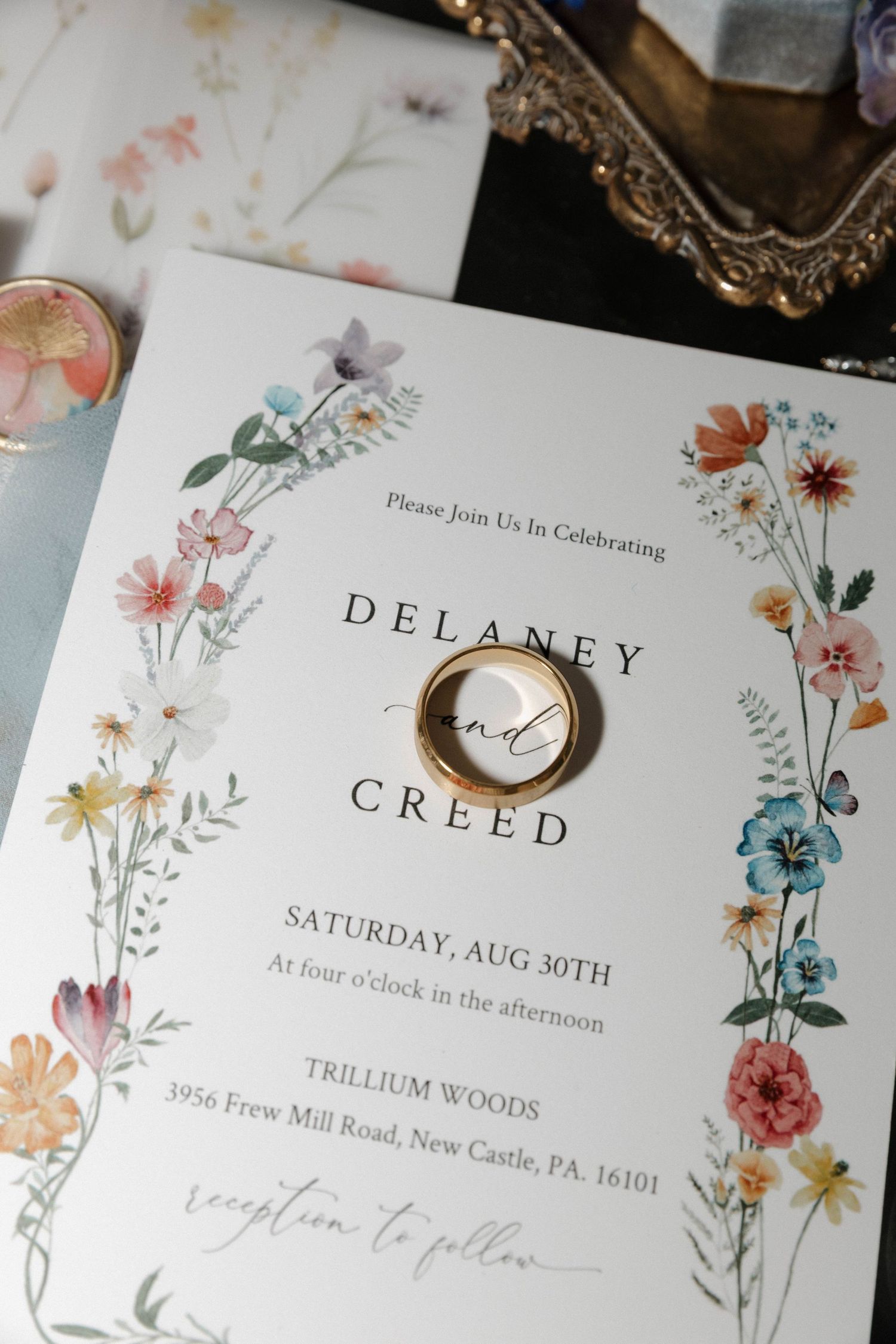 Floral wedding invitation with watercolor flowers and elegant typography on white paper.