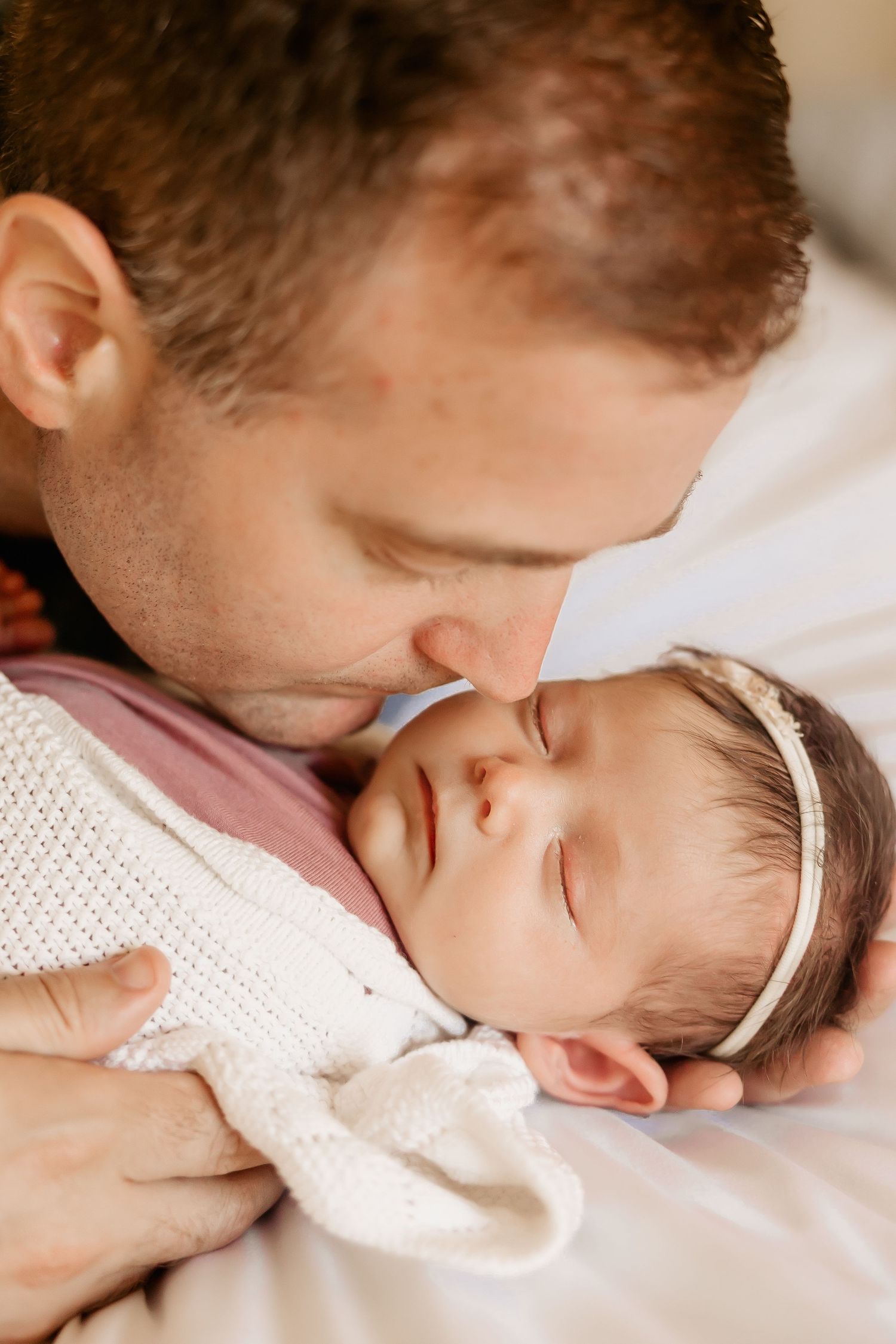 Honolulu Newborn Photographer captures a dad kissing his newborn baby girl.