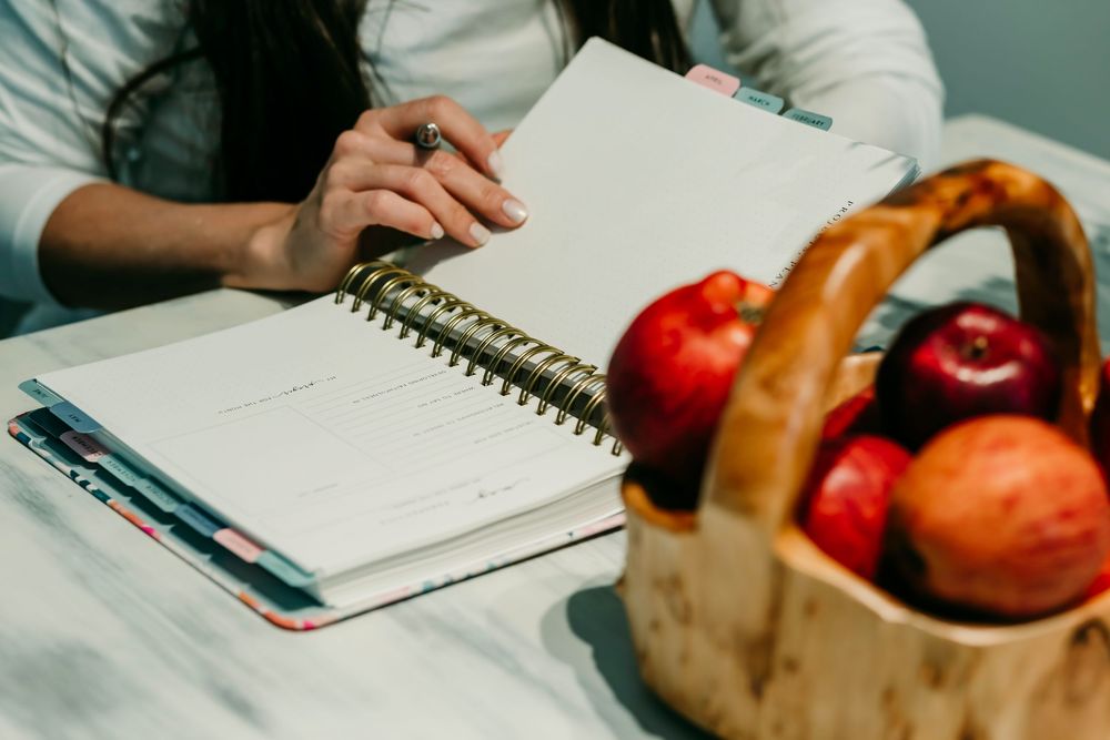 A woman is writing in a planner.