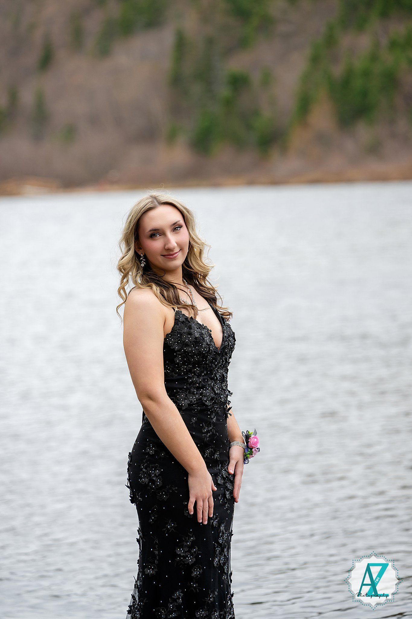 A glamorous evening photo by a serene lake featuring an elegant black sequined formal gown.