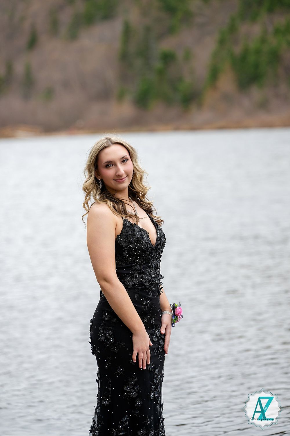 A glamorous evening photo by a serene lake featuring an elegant black sequined formal gown.