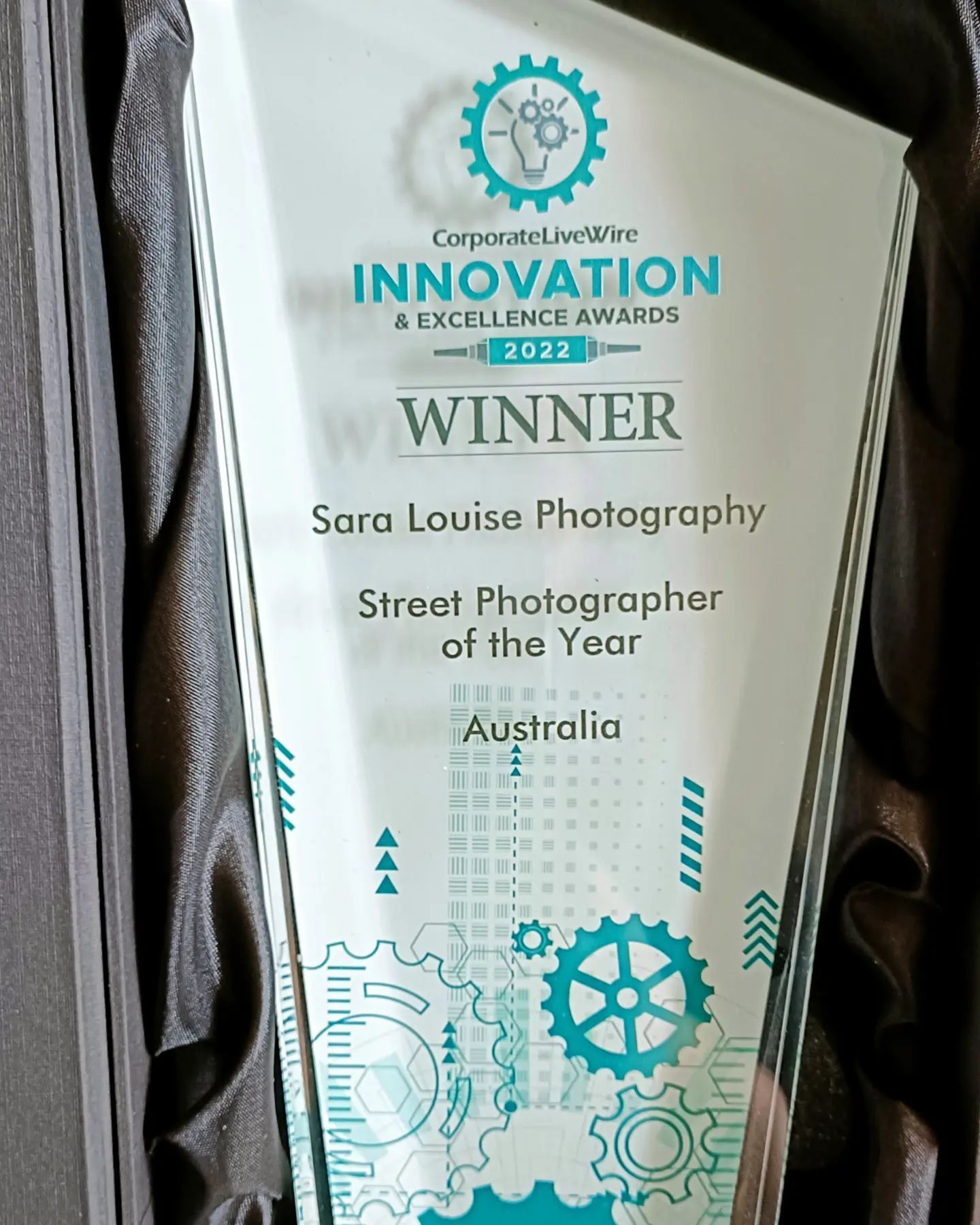 Glass trophy award for Street Photographer of the Year with teal geometric design elements.