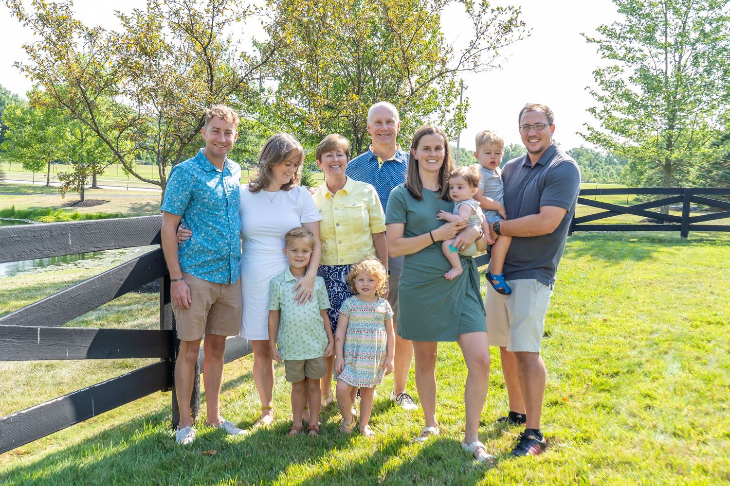 A casual outdoor family portrait at a park.