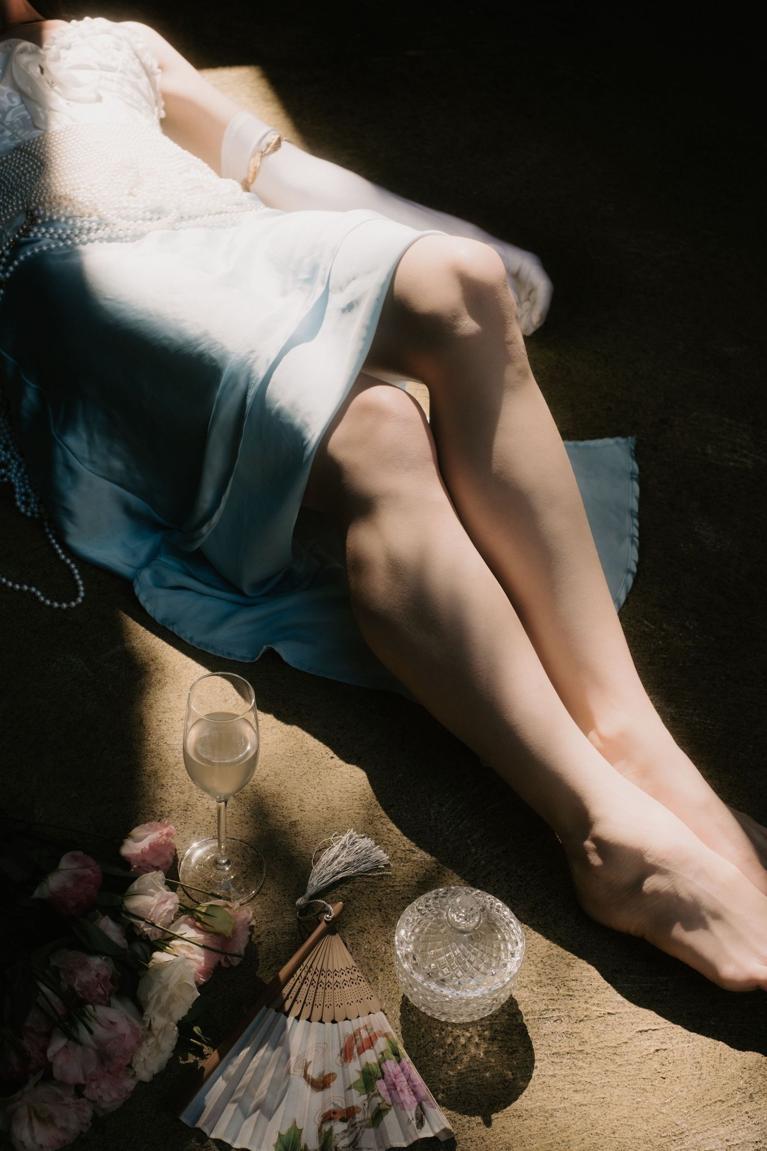 A dramatic series of cropped artistic photographs showing a person's legs and vintage glassware in atmospheric lighting.