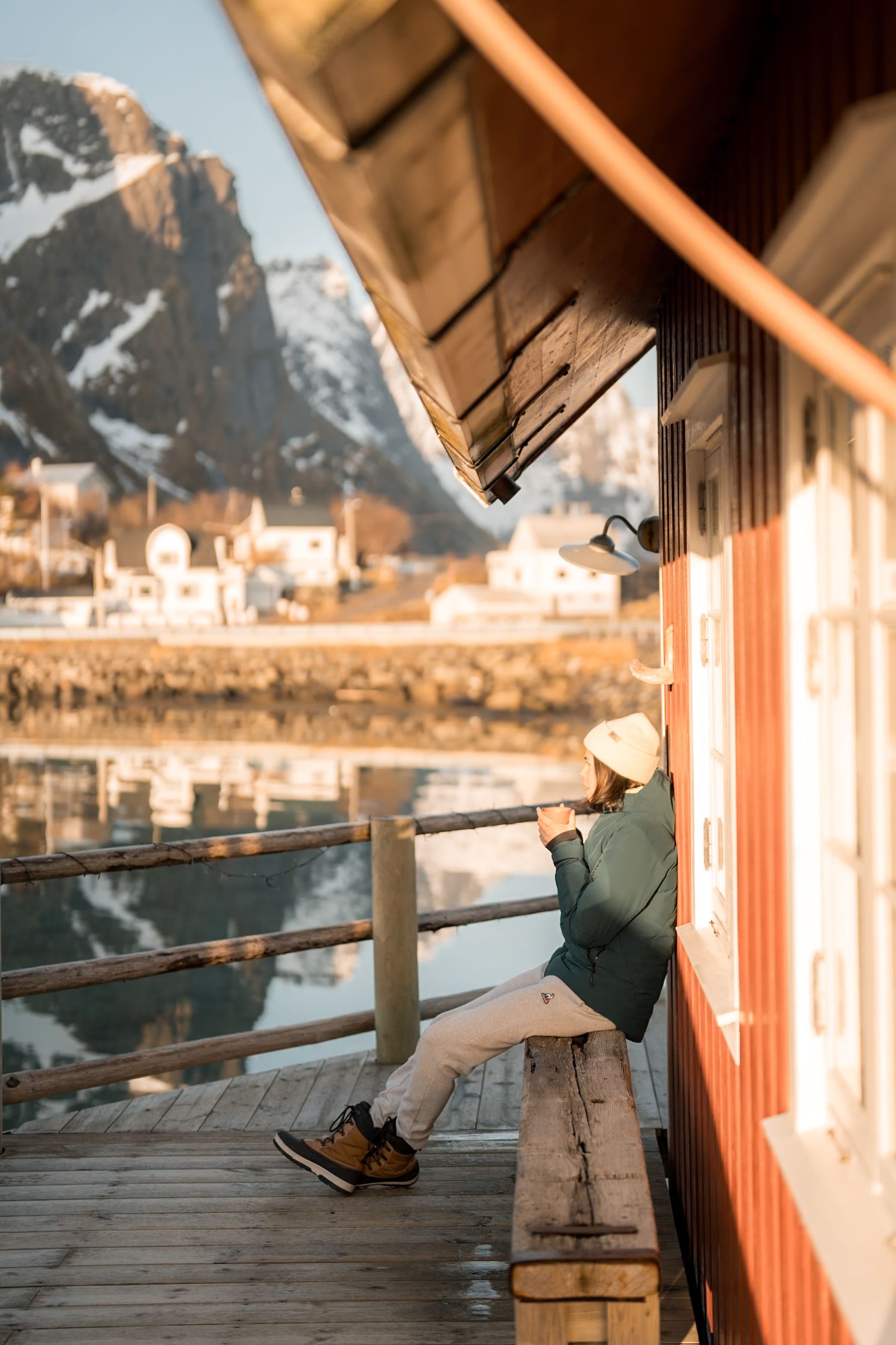 femme devant un rorbu à reine dans les lofoten